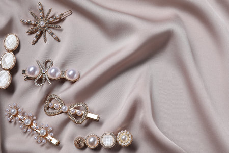Beautiful hair clips on beige fabric, flat lay. Space for textの写真素材