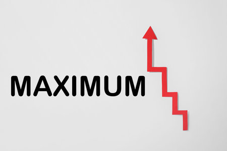 Word Maximum and red arrow on white background, top view