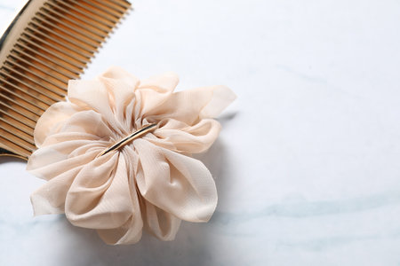 Beautiful hair clip and comb on white marble table, closeup. Space for textの写真素材