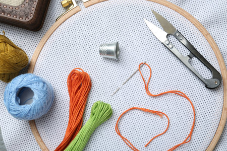 Different sewing supplies for embroidery on fabric, flat lay
