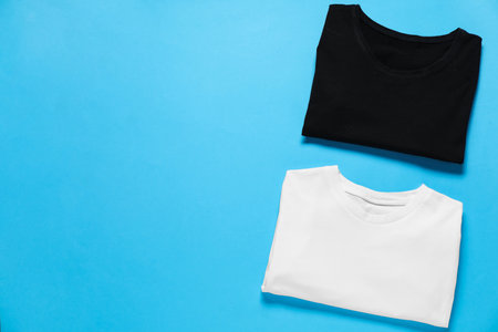 Blank t-shirts on light blue background, flat lay. Mockup for designの写真素材