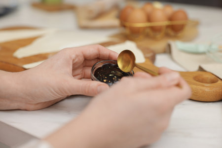 Woman with jam at white table, closeup. Making croissantsの写真素材