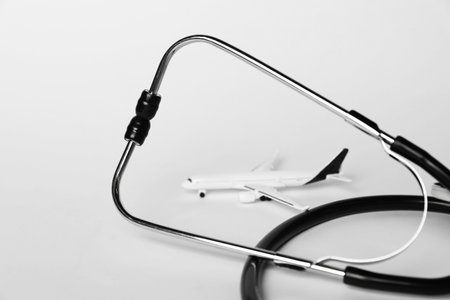 Stethoscope and airplane model on light background, closeupの写真素材