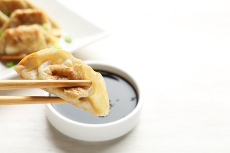 Eating fried gyoza dumplings at white table, closeupの写真素材
