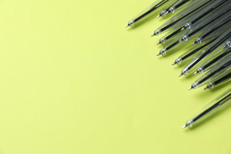 Many ballpoint pens on light green background, above view. Space for textの写真素材