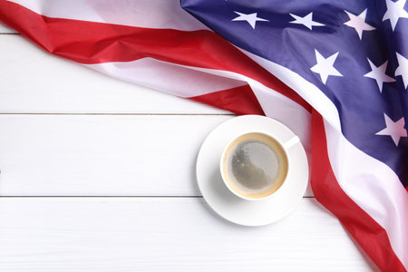 Cup of coffee and American flag on white wooden table, top view. Space for textの写真素材