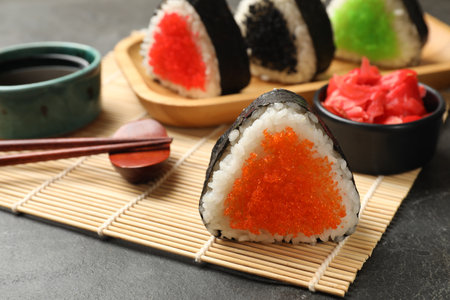 Tasty tobiko onigiri (Japanese rice balls) served on black table, closeupの写真素材