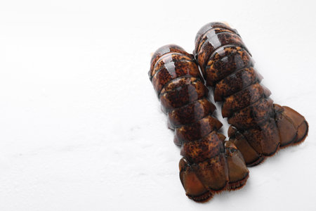 Raw lobster tails on white table, flat lay. Space for textの写真素材