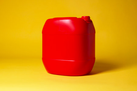 One red plastic canister on yellow background, space for textの写真素材