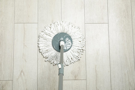 String mop on wooden floor, above view