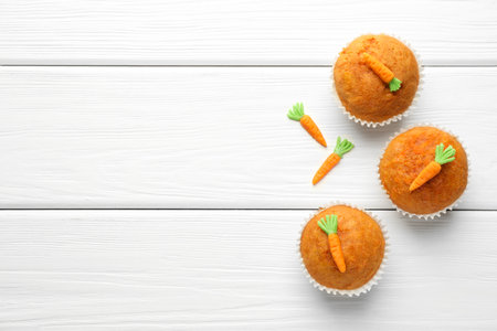 Tasty carrot muffins on white wooden table, flat lay. Space for textの写真素材