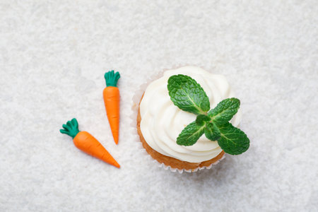 Delicious carrot cupcake with mint on light textured table, flat layの写真素材