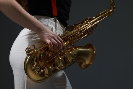 Professional musician with saxophone on grey background, closeupの写真素材