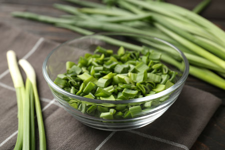 Cut fresh green onions in bowl on table, closeupの写真素材