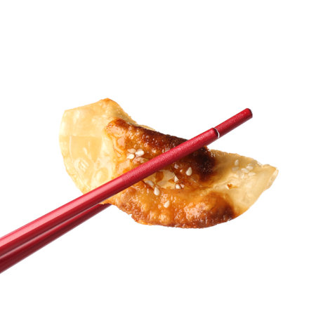 Holding tasty fried gyoza (dumpling) with chopsticks isolated on whiteの写真素材