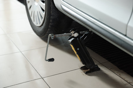 Car lifted by scissor jack at service stationの写真素材