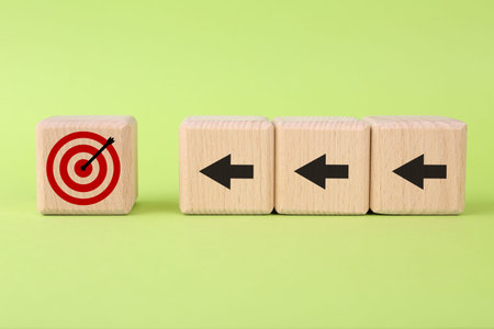 Targeting. Cubes with arrows pointing at one with bullseye on light green background