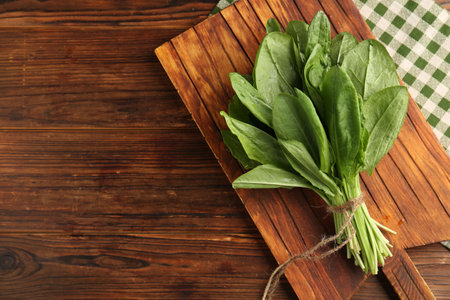 Bunch of fresh green sorrel leaves on wooden table, top view. Space for textの写真素材