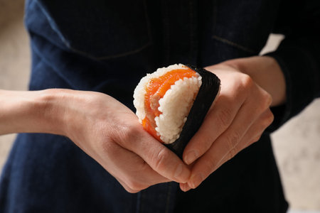 Woman with onigiri (Japanese rice ball) indoors, closeupの写真素材