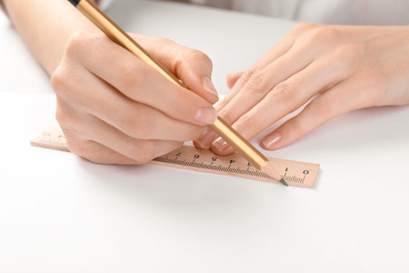 Woman drawing sketch with ruler and pencil on notebook at table, closeupの写真素材