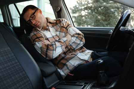 Tired driver sleeping in his modern carの写真素材