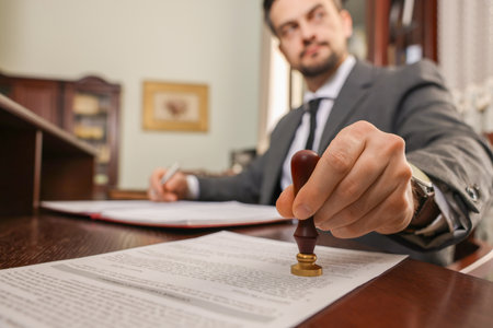 Notary stamping document at table in office, selective focusの写真素材