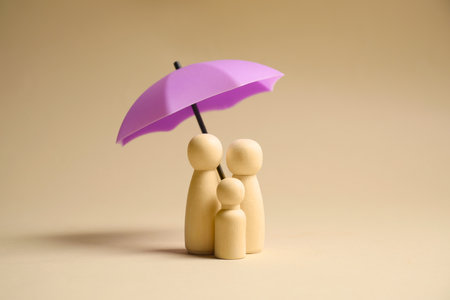 Human figures under umbrella on beige background. Insurance conceptの写真素材