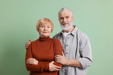 Portrait of lovely senior couple on green backgroundの写真素材