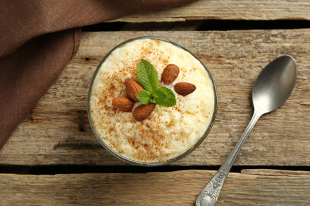 Delicious rice pudding with cinnamon, almonds and mint served on wooden table, top viewの写真素材