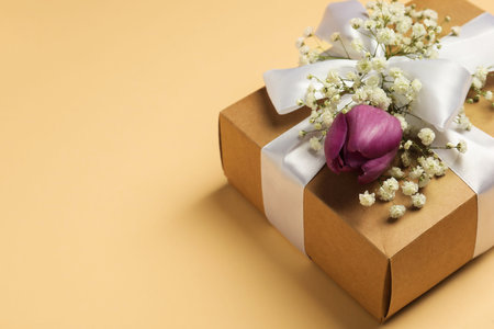 Florist. Box with flowers and ribbon on beige background, closeup. Space for textの写真素材