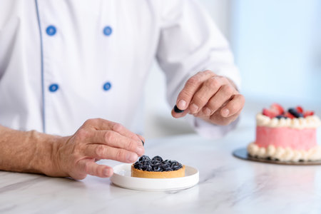 Pastry chef making dessert at white marble table in kitchen, closeupの写真素材
