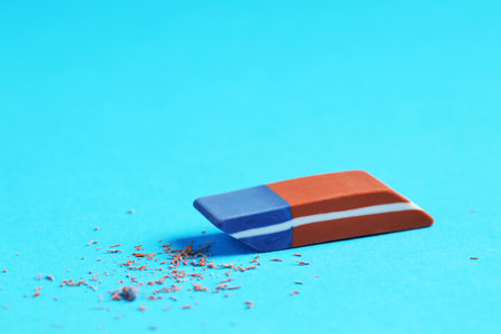 One eraser and scraps on light blue background, closeupの写真素材