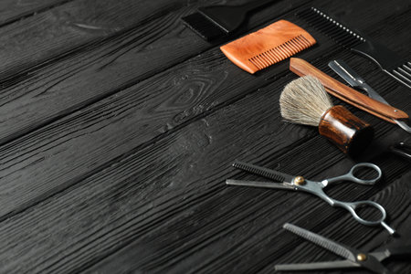 Many different barber's tools on black wooden table, closeup. Space for textの写真素材