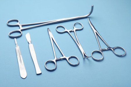 Different surgical tools on light blue background, closeup