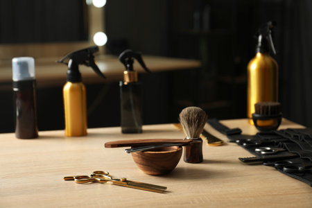 Many different barber's tools on light wooden table in barbershopの写真素材