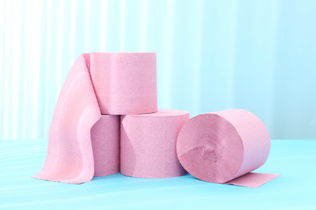 Pink toilet paper rolls on light blue backgroundの写真素材
