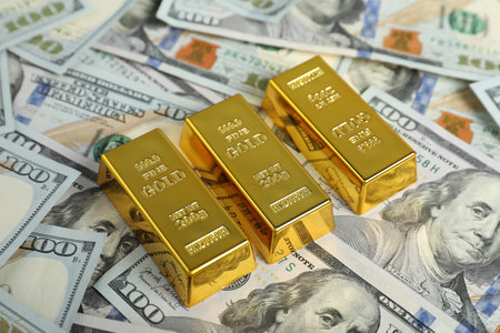 Shiny gold bars on dollar banknotes, closeupの写真素材