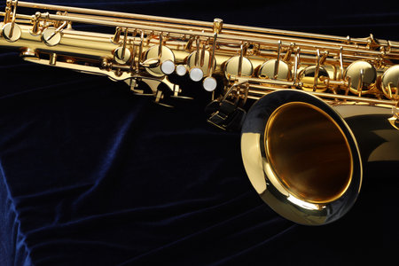 Jazz. One beautiful saxophone on dark blue fabric, closeup.の写真素材