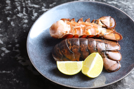 Raw lobster tails, lime and thyme on dark table, closeupの写真素材