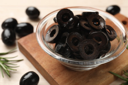 Delicious marinated olive rings, whole ones and rosemary on light table, closeupの写真素材