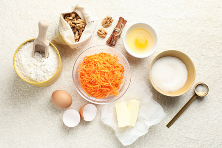 Different ingredients for making carrot cake on beige textured table, flat layの写真素材