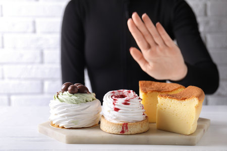 Woman refusing desserts at white table, closeupの写真素材