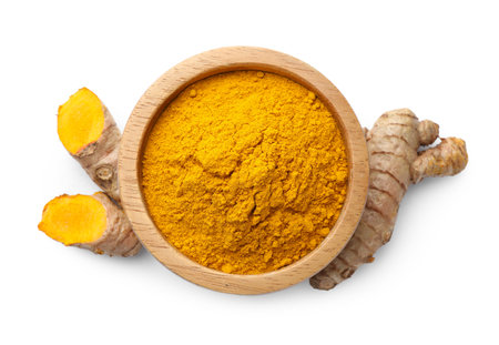 Turmeric powder in bowl and roots isolated on white, top viewの写真素材