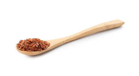 Raw brown rice and spoon isolated on whiteの写真素材