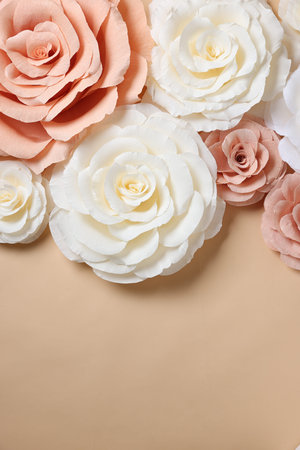 Beautiful paper flowers on beige background, flat lay. Space for textの写真素材