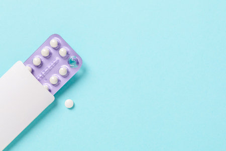 Blister of contraceptive pills in package on light blue background, top view. Space for textの写真素材
