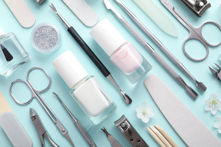 Set of different manicure tools and flowers on turquoise background, flat layの写真素材