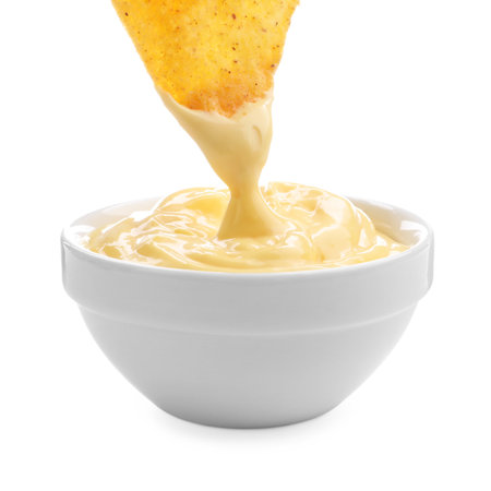 Dipping nacho chip into tasty cheese sauce on white background, closeupの写真素材