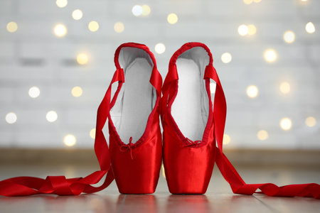 Pair of beautiful pointe shoes on floor against blurred lights. Bokeh effectの写真素材