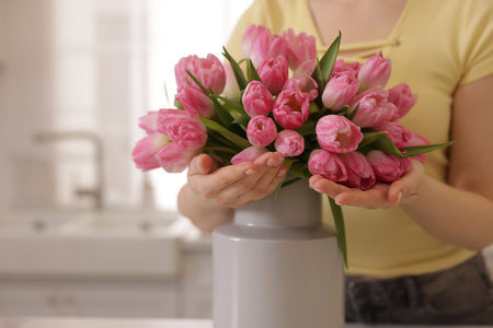 Woman with bouquet of pink tulips indoors, closeup. Space for textのeditorial素材